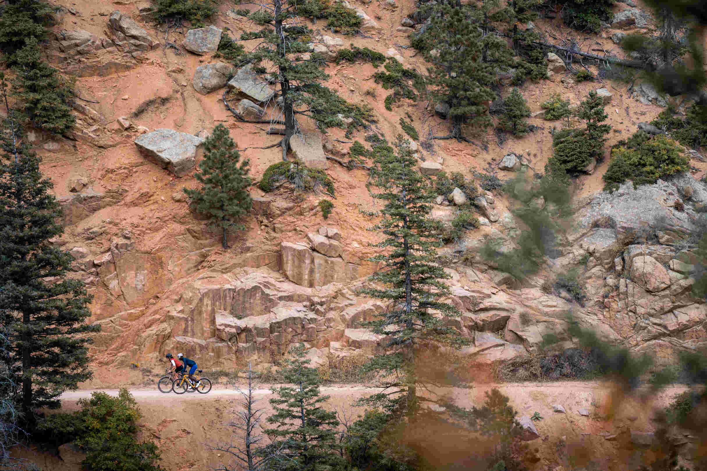 Cyclists Riding up a Dirt Road Mountain