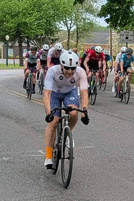 Cyclist racing in group wearing Cumberland Valley Collective team cycling kit made by Pactimo