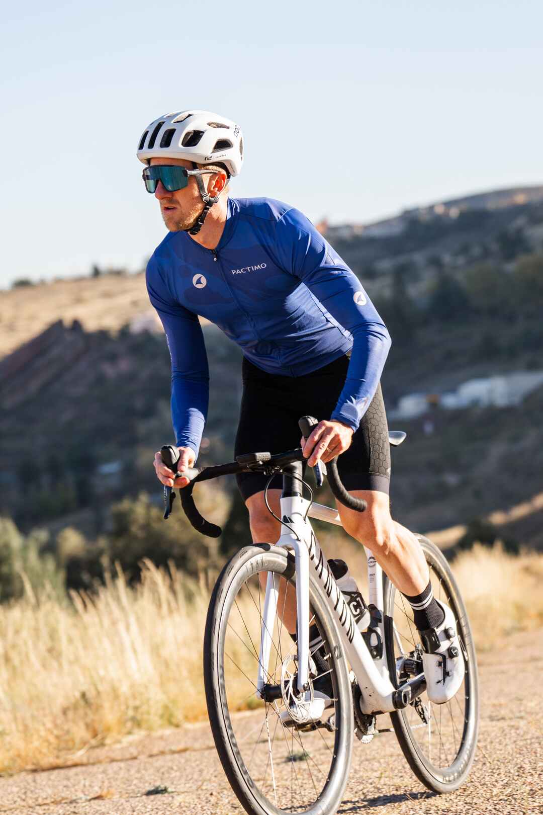 Male cyclist wearing long sleeve blue cycling jersey and Pactimo 12-Hour Bibs