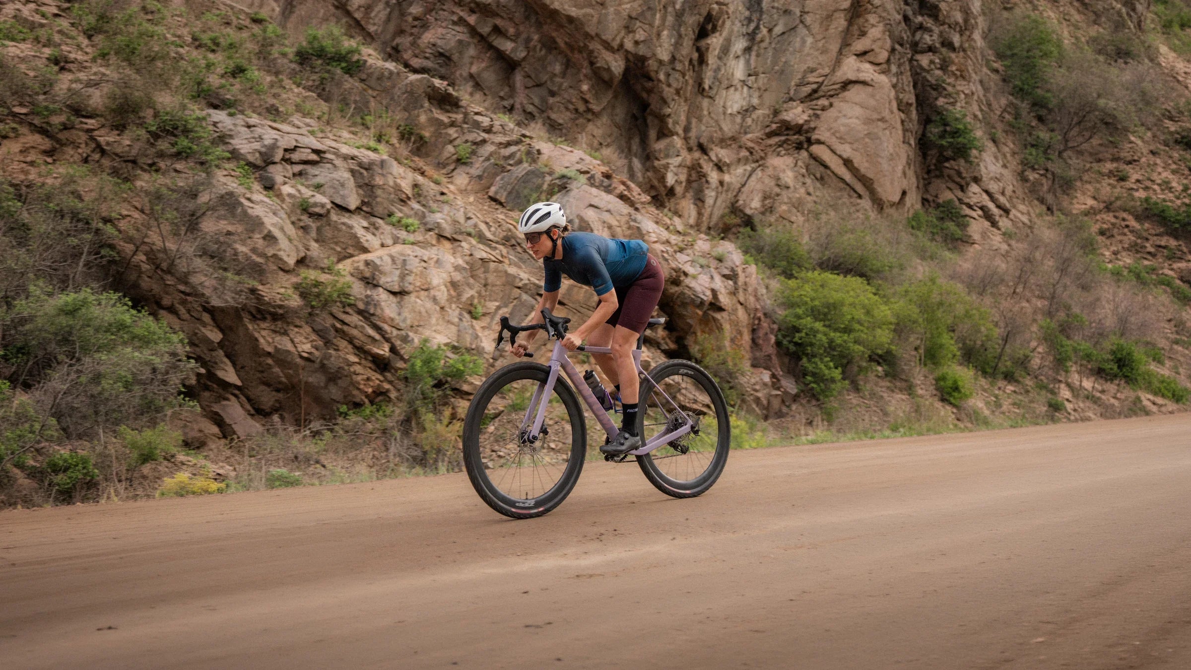 Female cyclist on a dirt road in a canyon