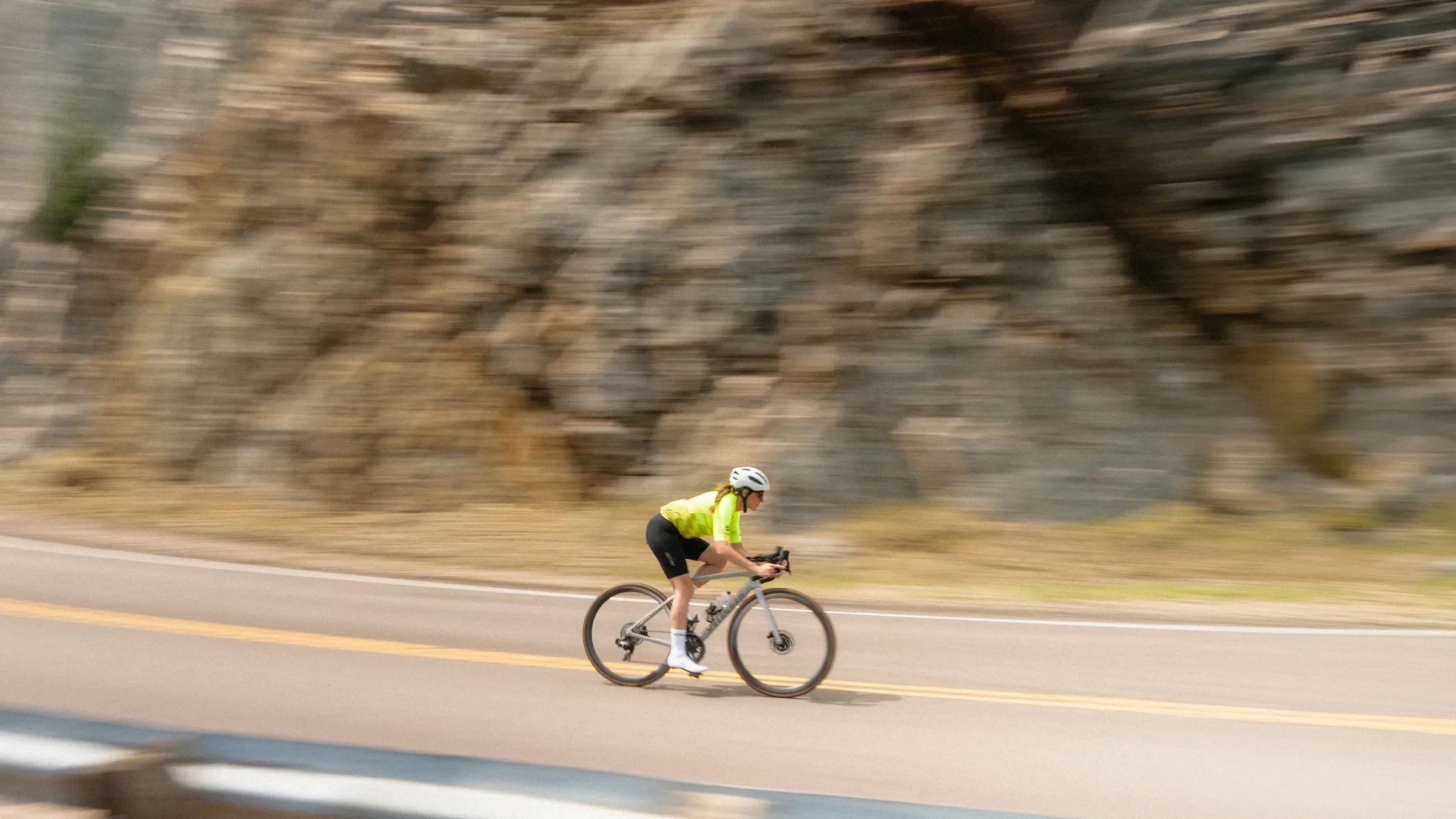 Female cyclist descending mountain road in the drops