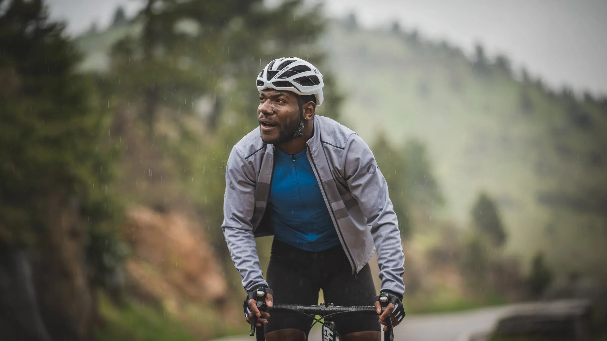 a male cyclist riding in the Colorado mountains during a rian storm
