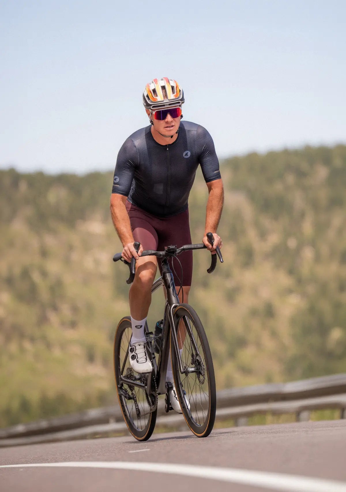 Male cyclist riding on a road with a scenic background