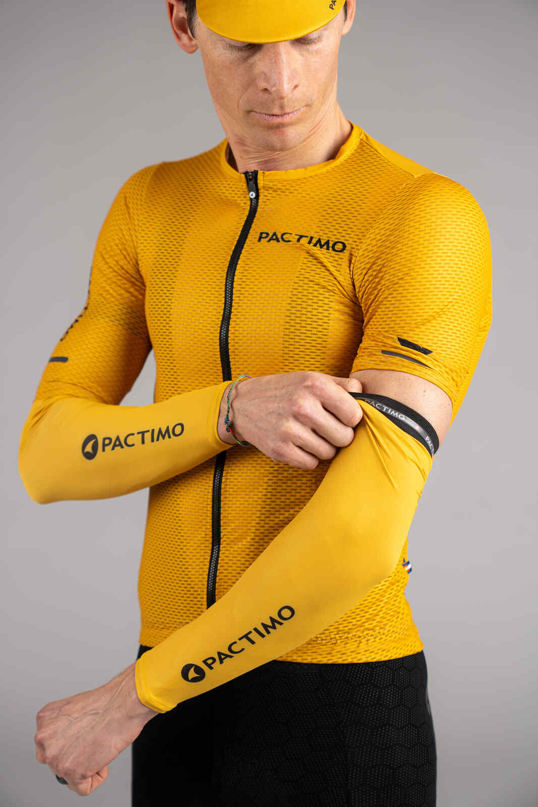 Cyclist putting on cycling sun sleeves in yellow