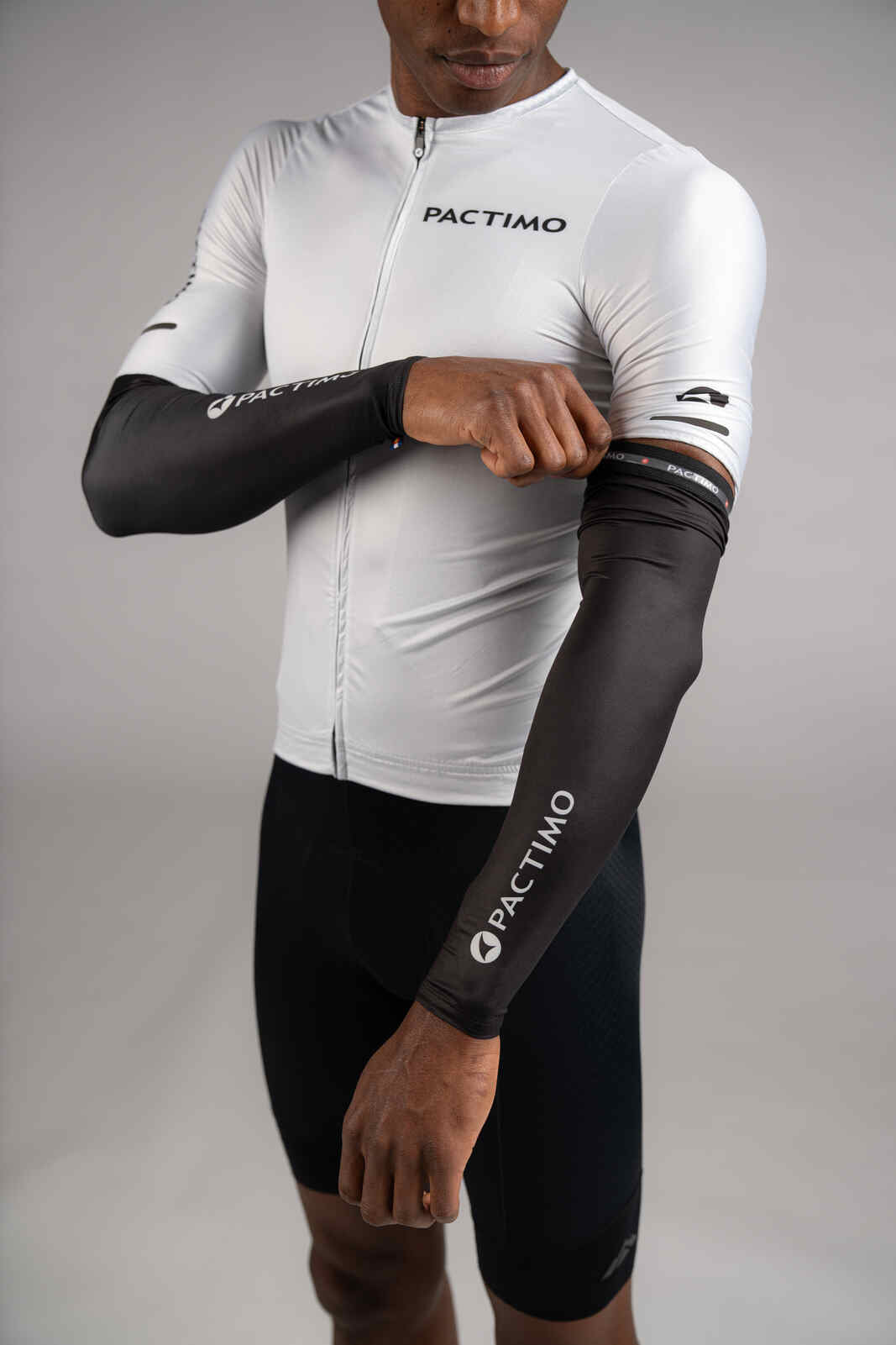 Cyclist putting on cycling sun sleeves in black
