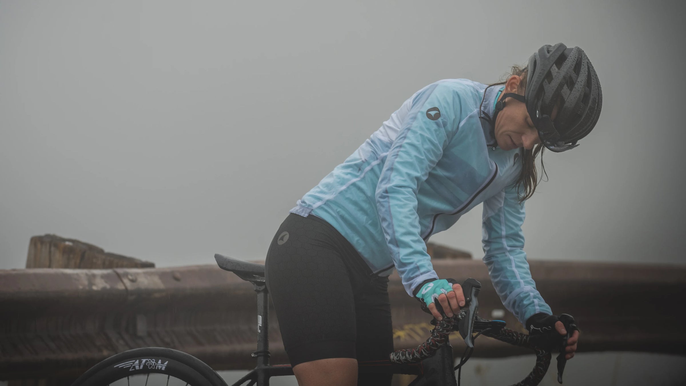 a female cyclist in the rain with a Pactimo Ultra-Lite Rain Jacket